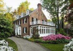 American traditional center hall colonial revival brick home with dormers.